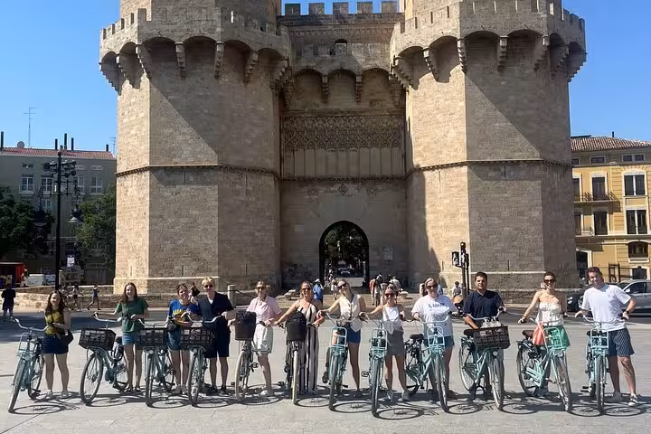 Dutch Valencia bike tour group lined up with bicycles at Torres de Serranos medieval gate in old town