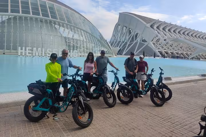 Ruzafa guided bike tour group with e-bikes at Valencia Hemisfèric and Science Museum in City of Arts and Sciences