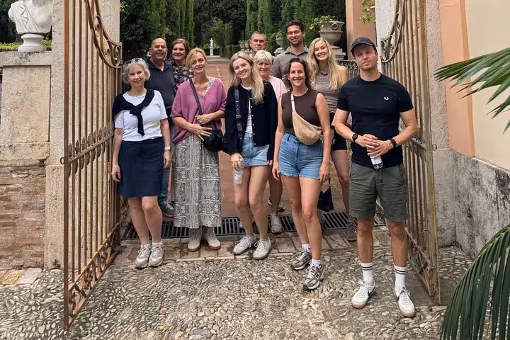 Small group in Ruzafa at a garden gate before a guided Valencia bike tour of top city highlights