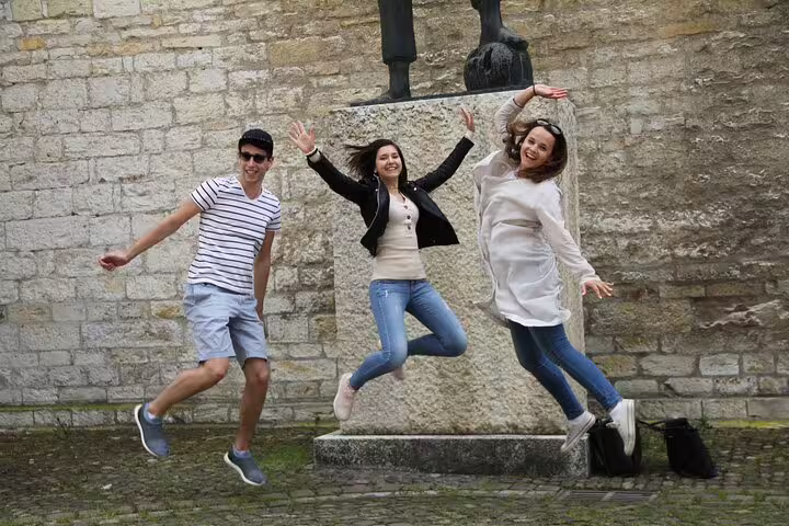 Group jumping by a historic Valencia monument during an iconic sights scavenger hunt walking tour challenge