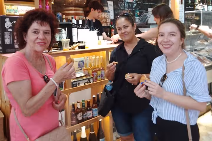Guests sampling tapas in a Valencia market bar during the gourmet tapas tour by bike or on foot
