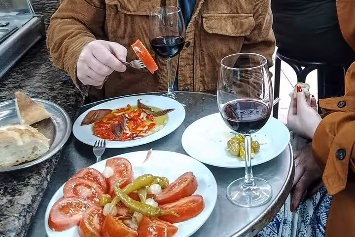 Close-up of Valencian tapas with local red wine, tomato salad and peppers on the Valencia gourmet tapas tour