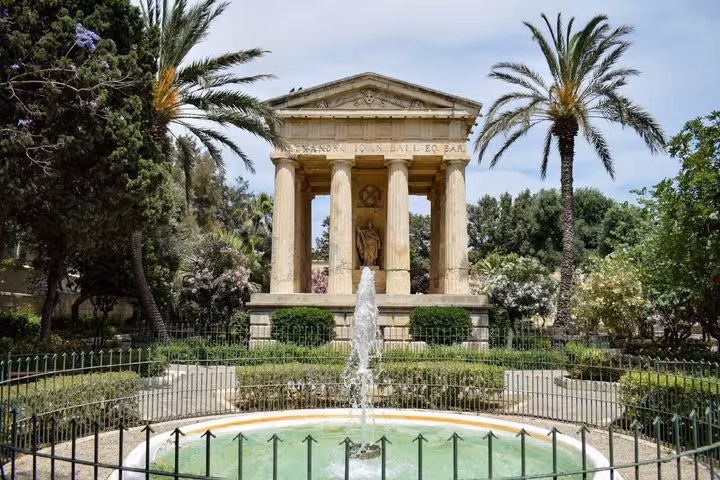 Lower Barrakka Gardens fountain and neoclassical monument with palm trees in Valletta, Malta