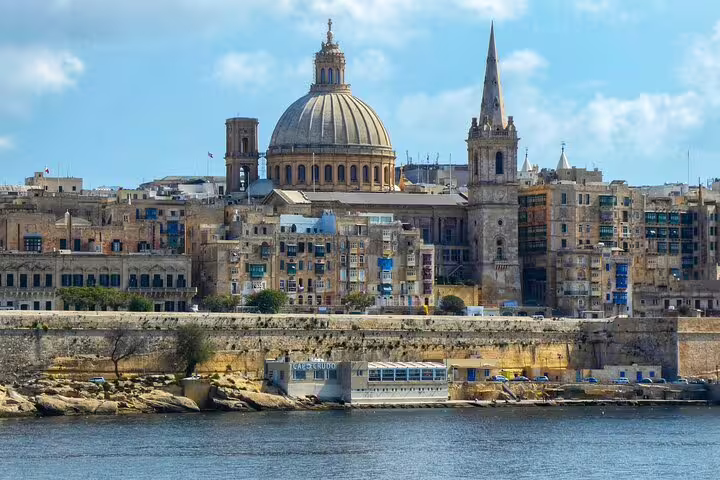 Valletta skyline with iconic dome of St Paul's Pro-Cathedral and city fortifications viewed from the sea