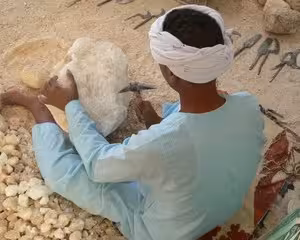 Artisan carving limestone sculpture near Valley of the Kings, Luxor Egypt