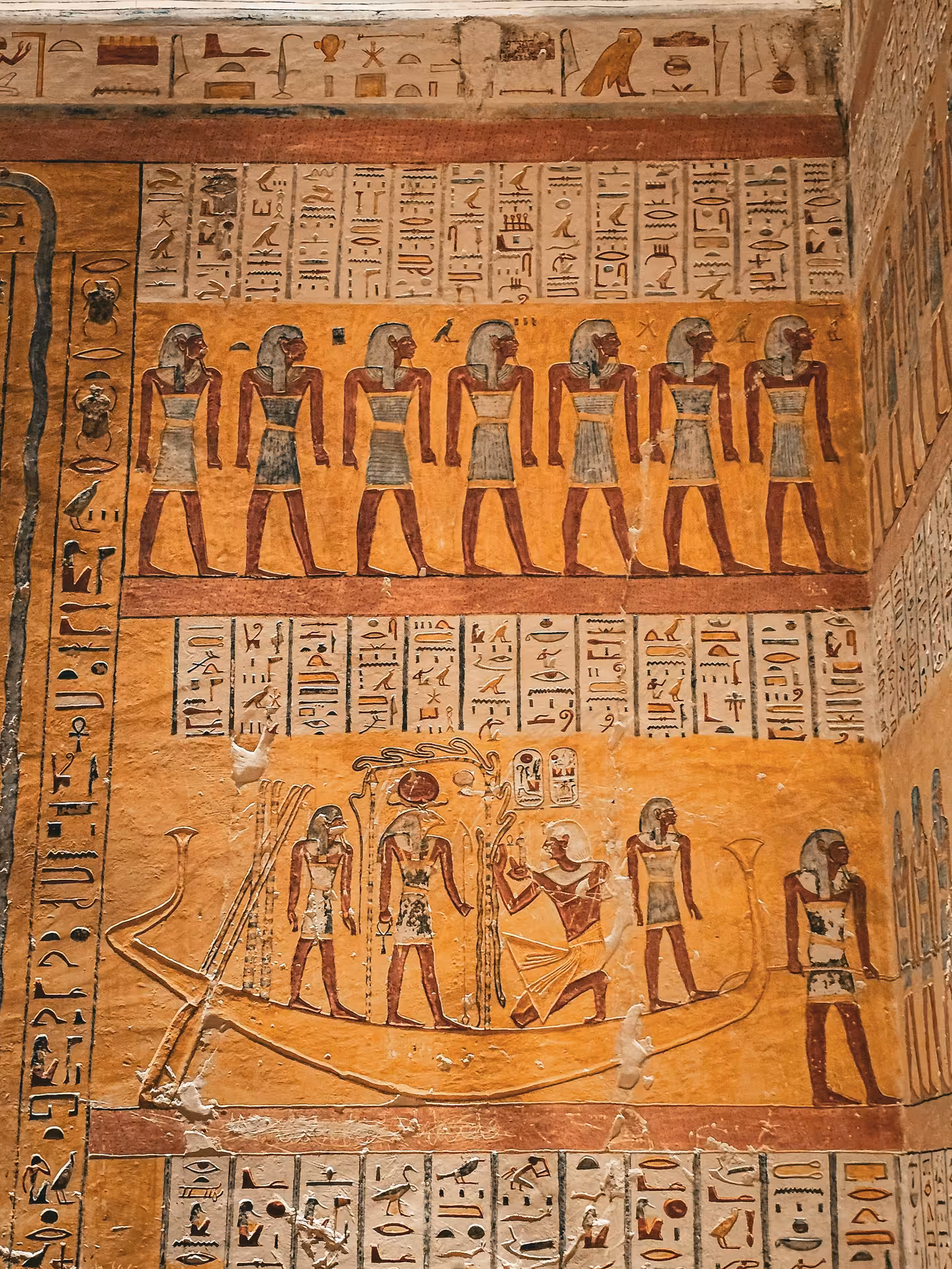 Ancient Egyptian hieroglyphics and painted figures on tomb wall in Valley of the Kings