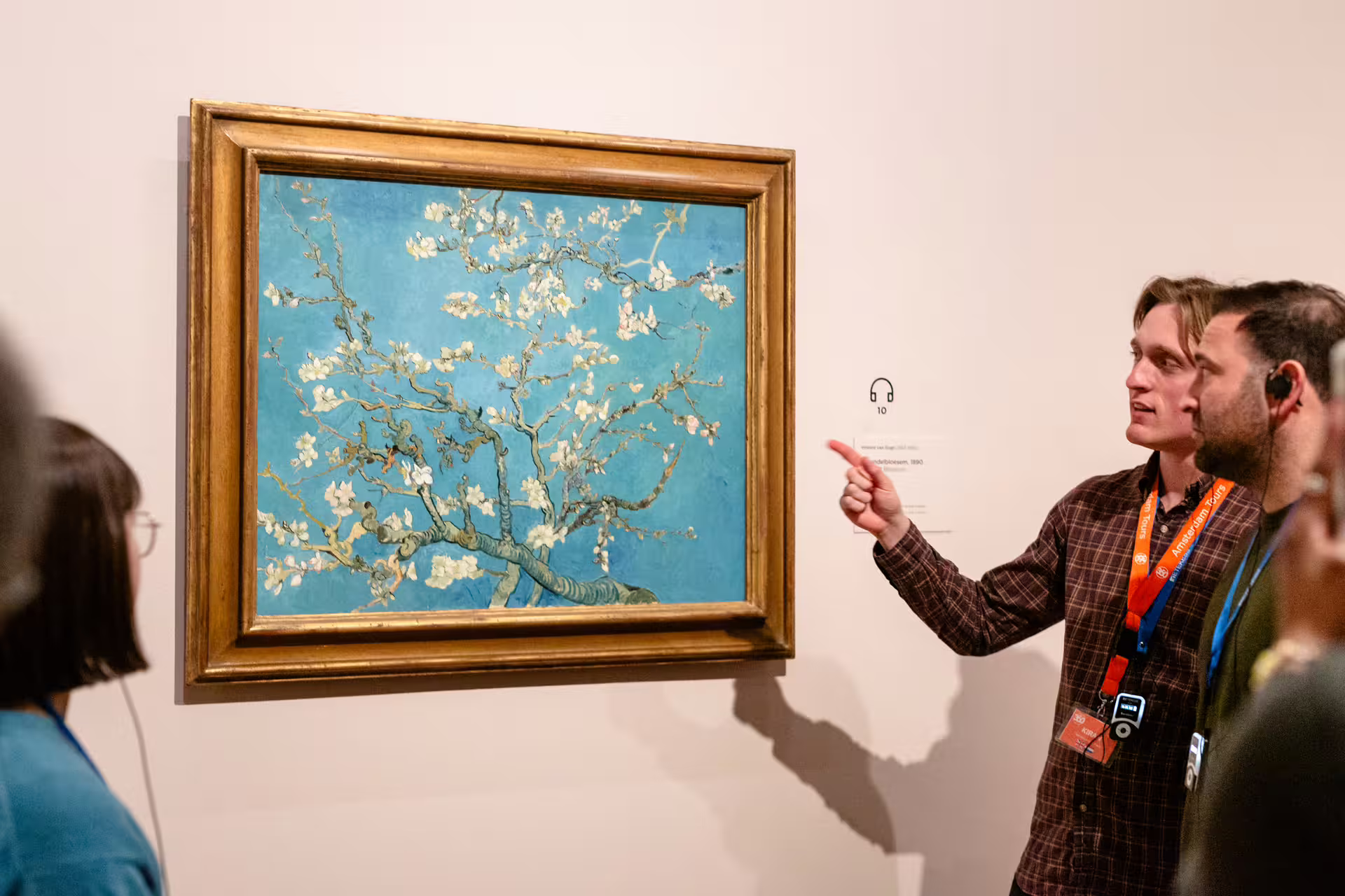 Visitors engage with Van Gogh's "Almond Blossom" painting during an insightful guided tour, enhancing their art appreciation.