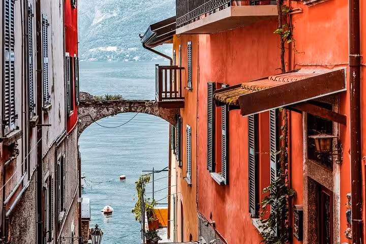 Colorful Varenna alley with arch bridge and Lake Como views, part of Milan to Como Bellagio Varenna cruise tour