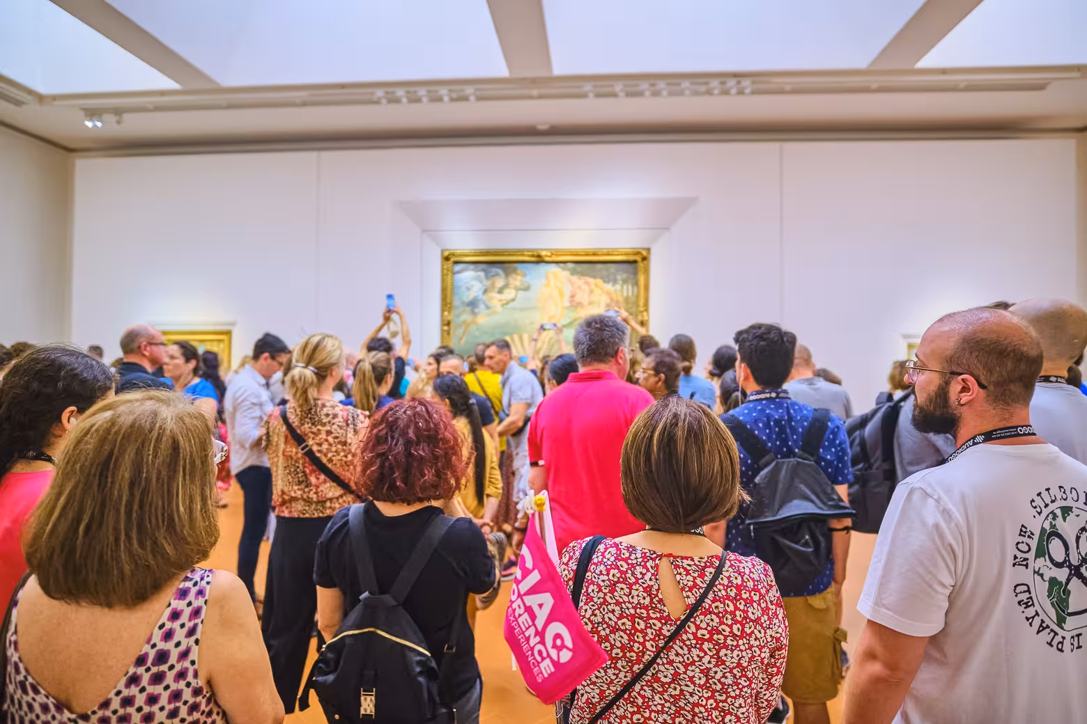 Tourists gather around a famous painting at the Uffizi Gallery, capturing the essence of Florentine art and culture.