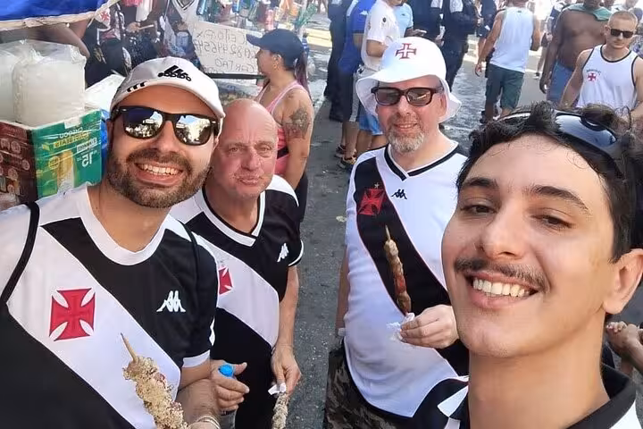Local guide and guests in Vasco da Gama shirts enjoying street food before a Rio de Janeiro matchday experience