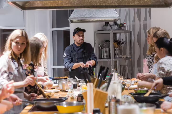 Chef leads interactive cooking class with participants at The Vatican Market Experience, showcasing Italian culinary skills.