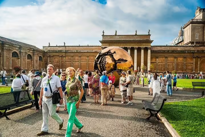 Guided group exploring Vatican Museums courtyard with modern bronze globe sculpture on fast track Colosseum and Vatican tour