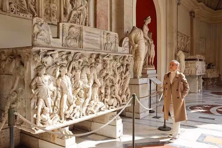 Visitor admiring Roman sarcophagus reliefs inside Vatican Museums on skip-the-line hosted entry audio tour