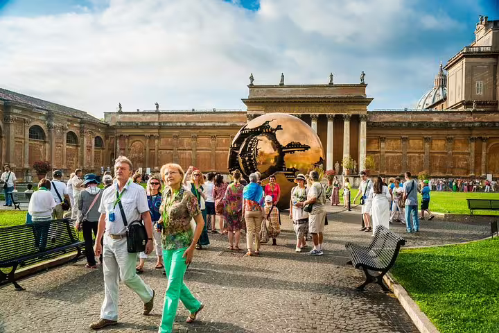 Tourists exploring the Vatican Museums courtyard with the Sphere Within Sphere sculpture on a Rome private VIP Sistine Chapel tour