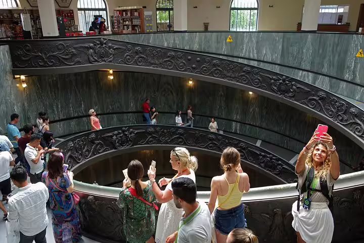 Visitors on a guided Vatican Museums tour exploring the ornate spiral staircase before entering the Sistine Chapel