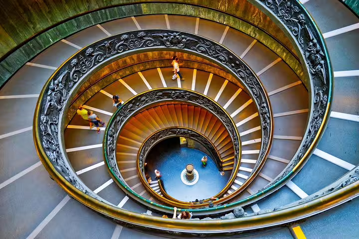 Visitors descend the iconic double spiral staircase inside the Vatican Museums on an exclusive Rome private guided tour