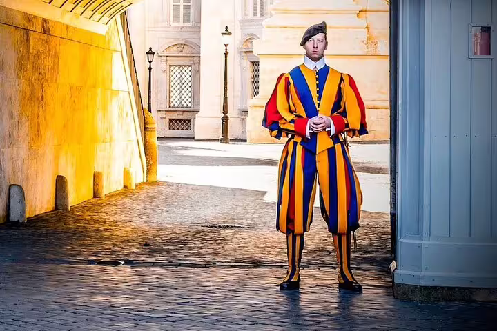 Colorful Vatican Swiss Guard in traditional uniform standing on duty, iconic stop on exclusive family Vatican Museums tour