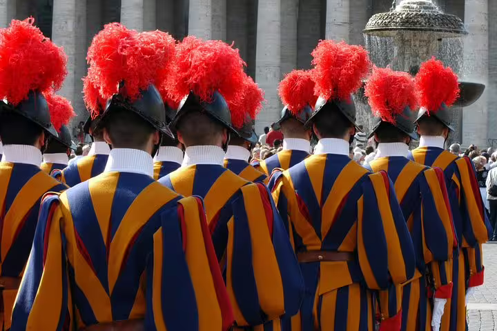 Colorful Vatican Swiss Guards in traditional uniforms standing in formation during an Exclusive Sistine Chapel fast track tour