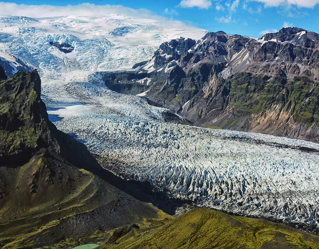 Aerial view of Vatnajokull glacier flowing through mountain valley in Skaftafell Iceland