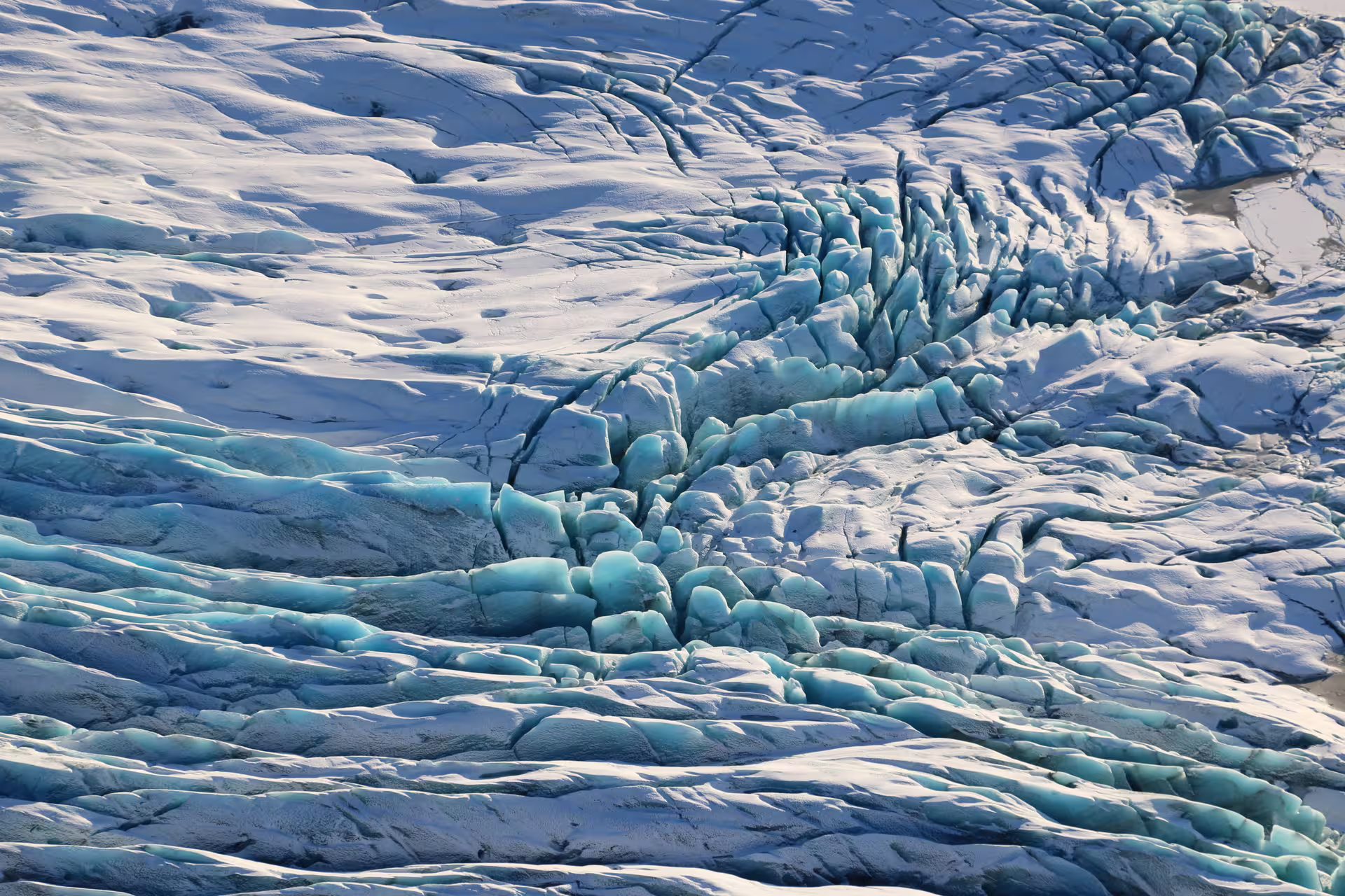 Aerial view of Vatnajokull glacier crevasses with blue ice formations in Iceland