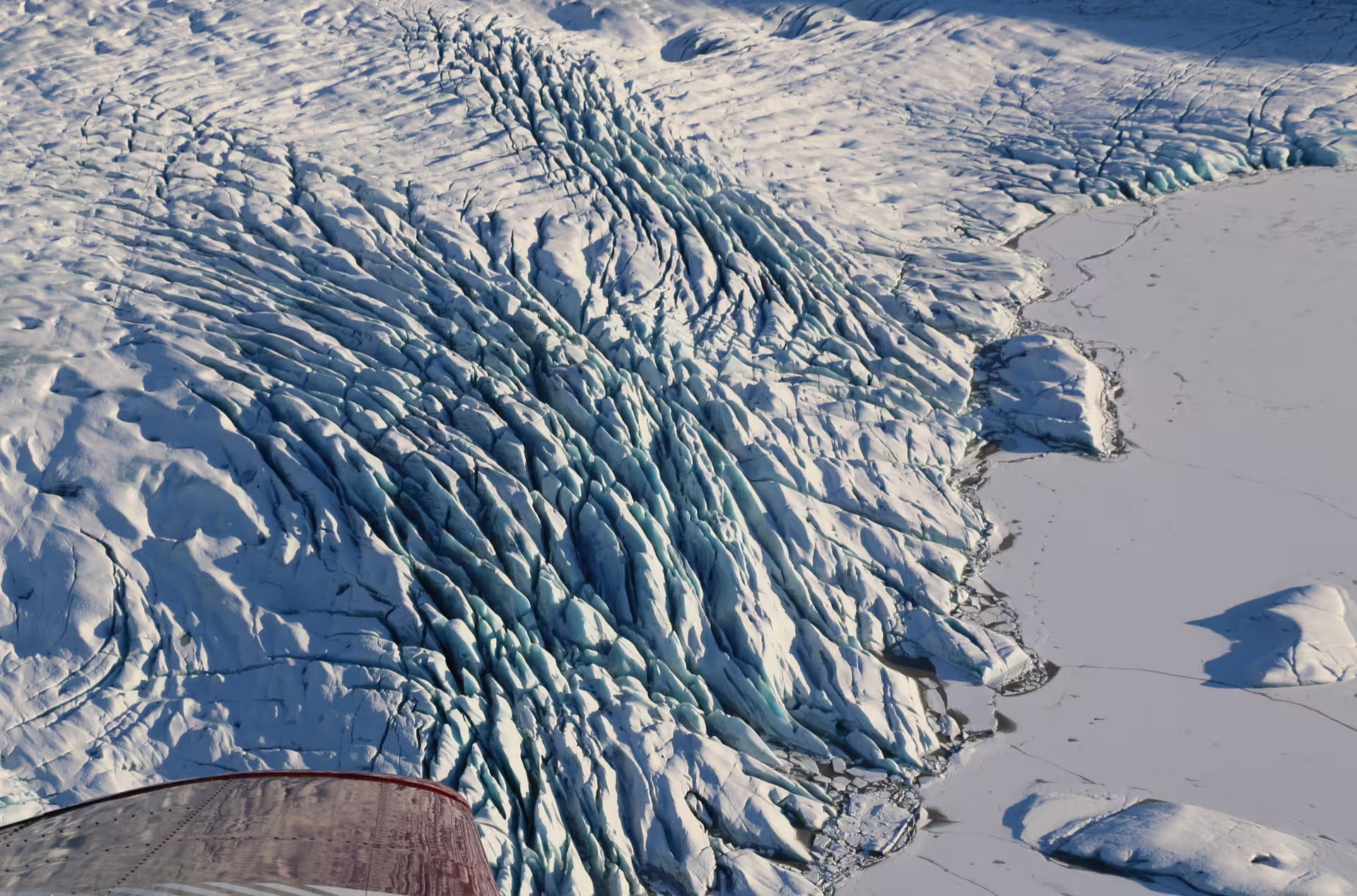Aerial view of Vatnajokull glacier crevasses and ice formations from airplane window, Iceland