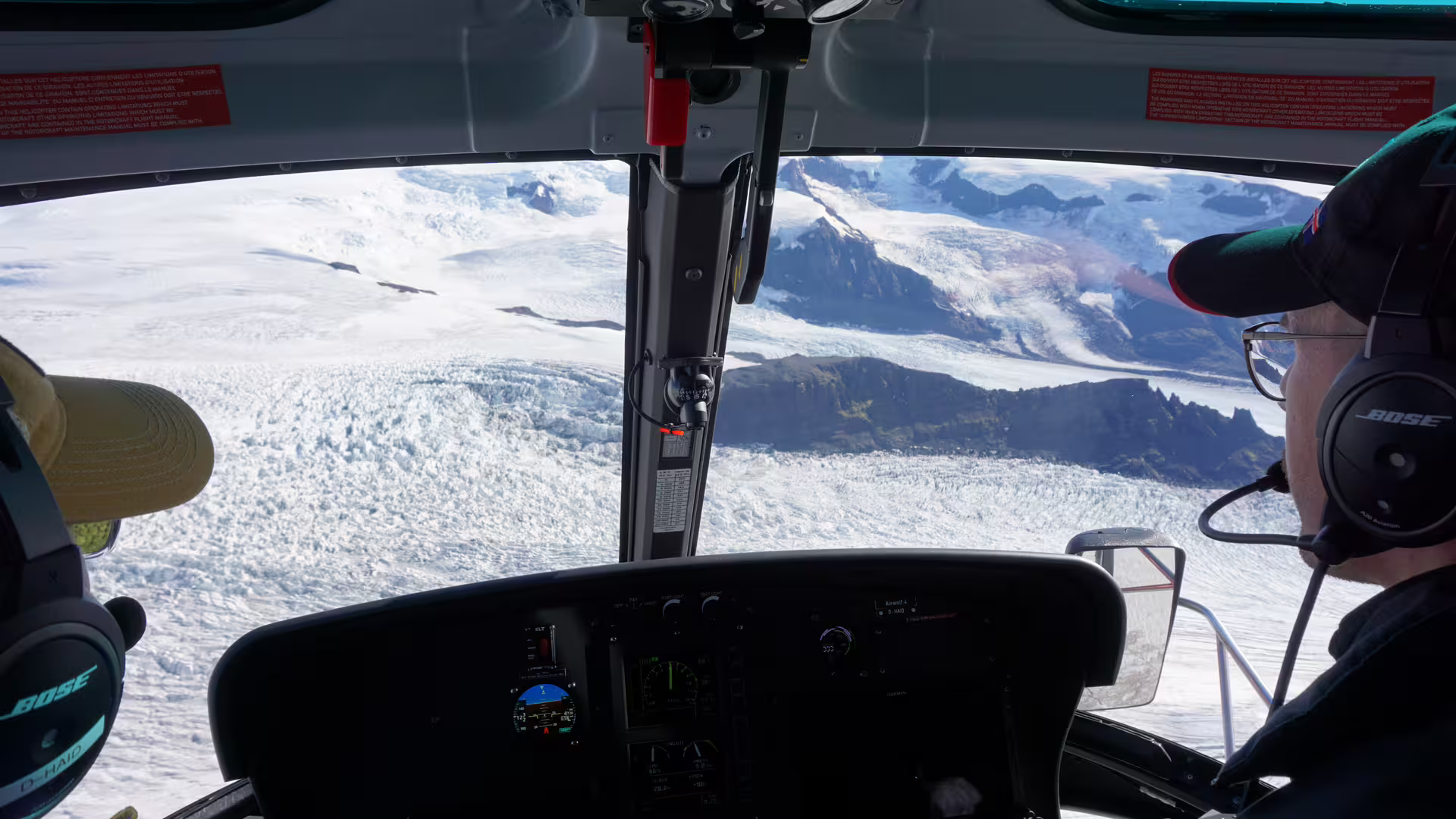 Helicopter cockpit view over Vatnajokull glacier and snow-capped mountains in Iceland