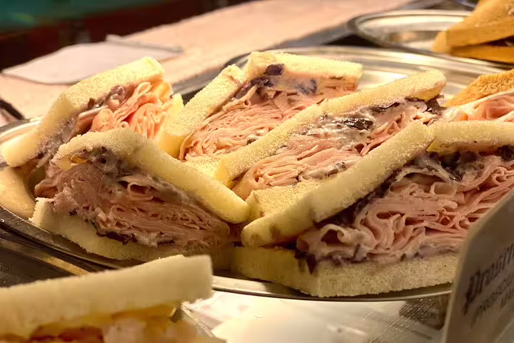 Freshly made Venetian tramezzini sandwiches loaded with prosciutto served at a local Venice street food market