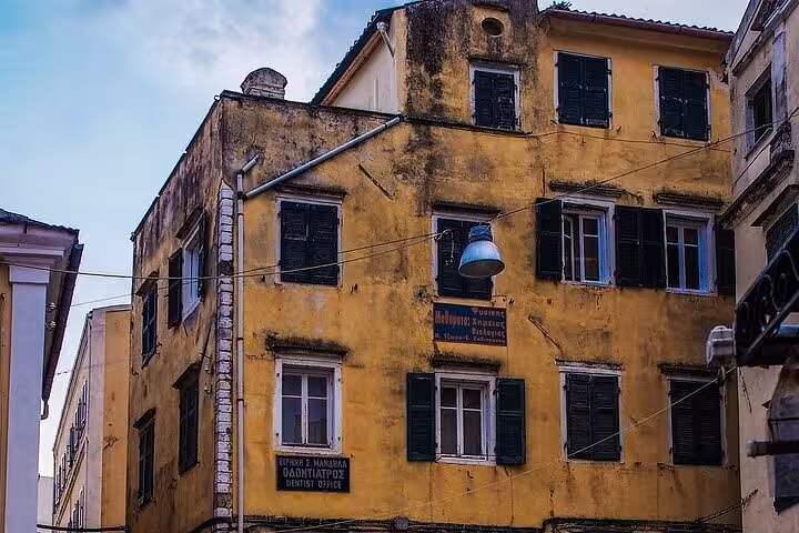 Weathered Venetian-era yellow building with shutters in Old Corfu Town on a private walking guided tour