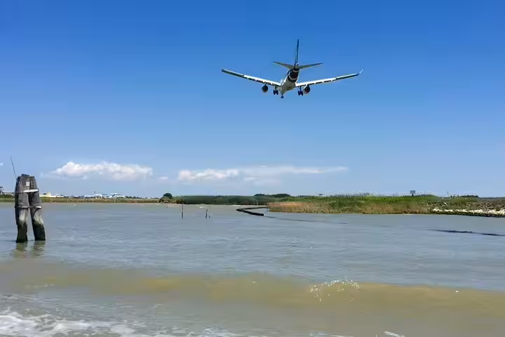 Plane landing near Venice Marco Polo Airport over lagoon, start of private transfer to Venice city center hotel