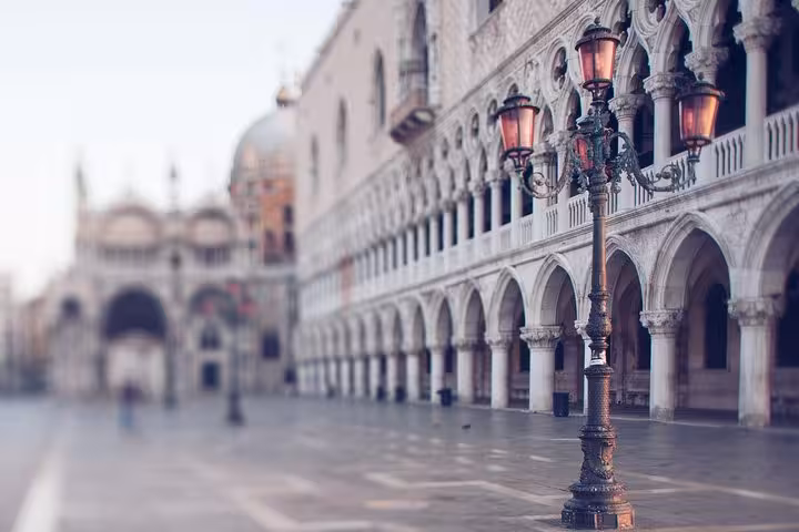 Scenic view of Venice's historic Doge's Palace with ornate arches, perfect for a walking tour and gondola ride.