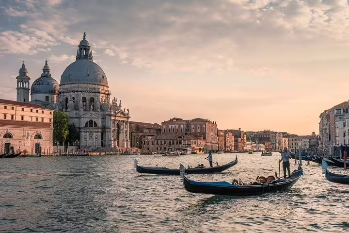Gondolas gliding past Basilica di Santa Maria della Salute on the Grand Canal during a last minute Venice private tour