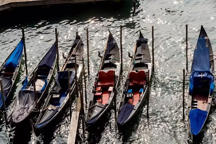 Row of traditional gondolas moored along the shimmering waters of Venice's iconic canals.