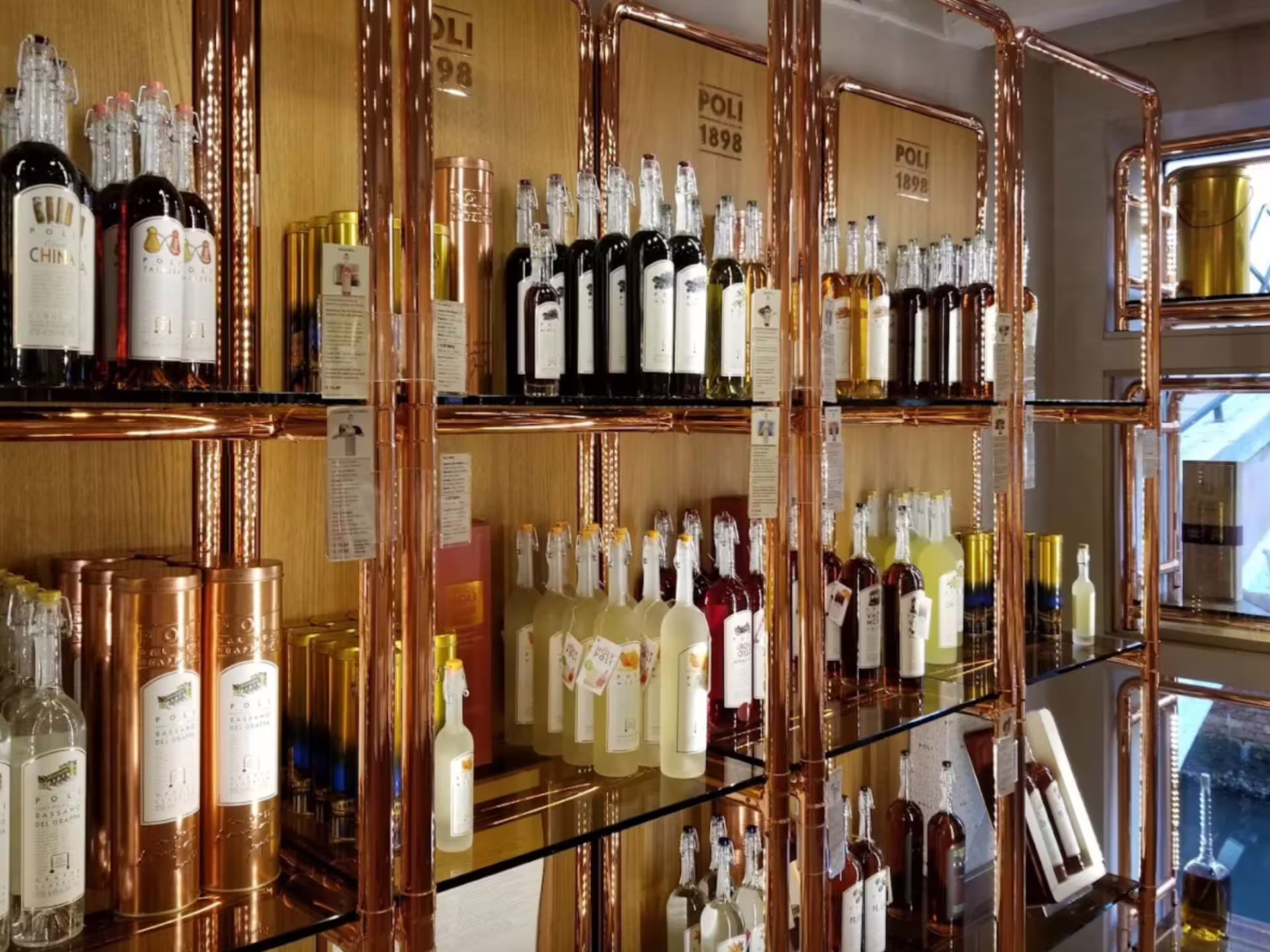 Interior shelves in a Venice grappa shop filled with diverse bottles, perfect for an immersive tasting experience.