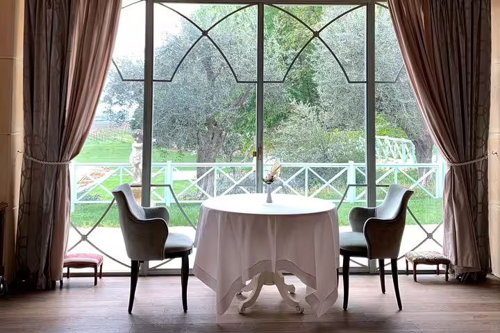 Elegant dining setup by large window overlooking picturesque garden on Venice to Milano private scenic transfer.
