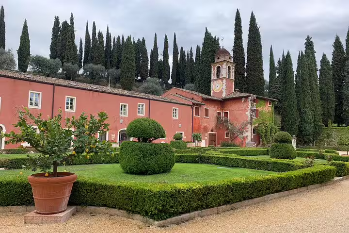 Charming Italian villa with lush garden and towering cypress trees on scenic Venice to Milano transfer route.