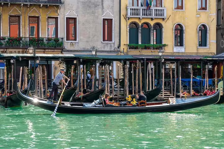 Private gondola gliding along a quiet Venice canal, passing historic palazzi and wooden moorings on a romantic guided ride