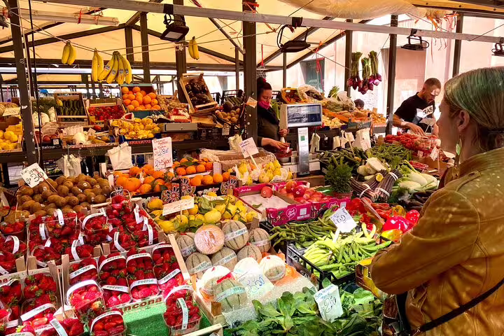 Vibrant Venice Rialto Market stall overflowing with fresh fruits and vegetables on a street food walking tour