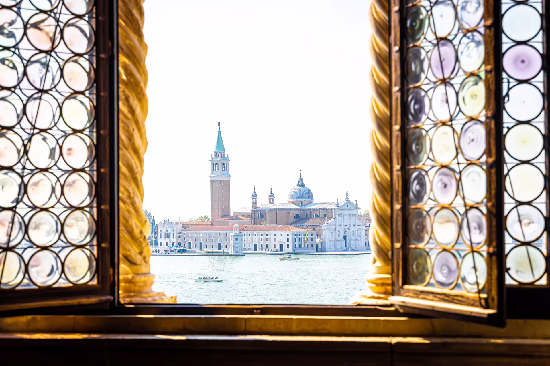 Panoramic view of San Giorgio Maggiore across the Venetian Lagoon framed by ornate windows on a private Venice highlights tour