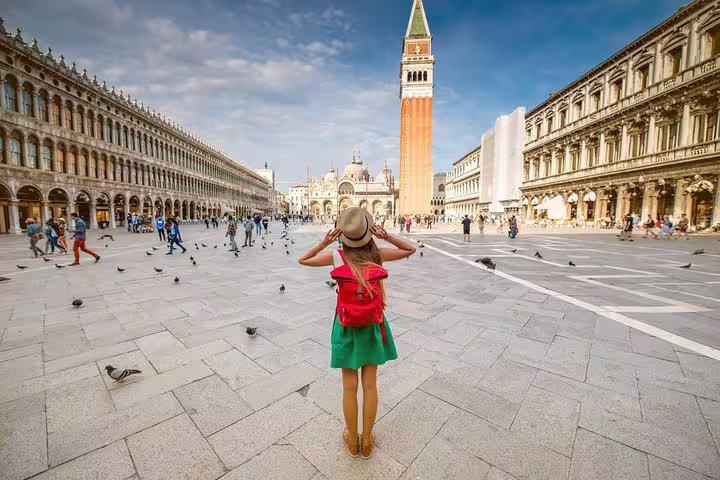 Traveler in St Mark’s Square facing the basilica and campanile in Venice, enjoying a guided skip-the-line walking tour