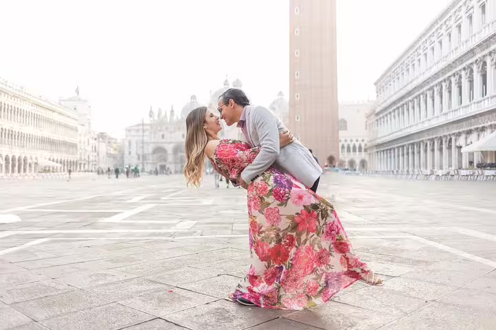 Venice St Mark’s Square city portrait session, couple dip kiss in floral dress at sunrise in Piazza