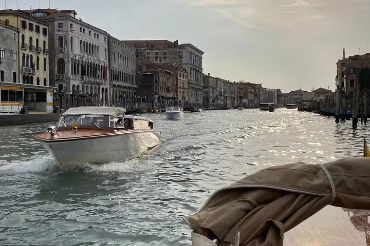 Elegant water taxi cruising along Venice's Grand Canal, providing seamless hotel transfer to VCE airport.