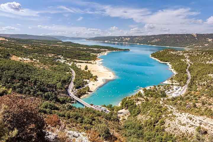 Aerial view of turquoise Lake Sainte-Croix surrounded by forested hills in Verdon Gorge, France