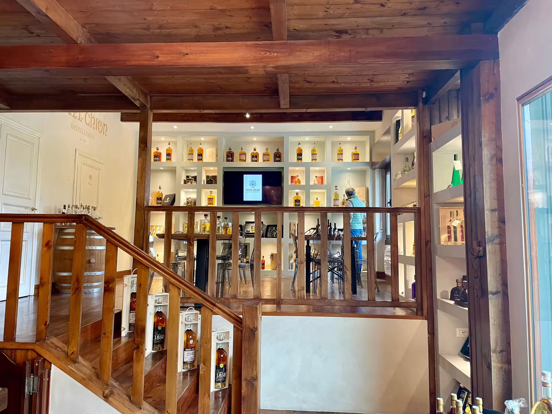 Elegant tasting room with wooden decor and bottles on display at a Turin distillery, ideal for spirits enthusiasts.