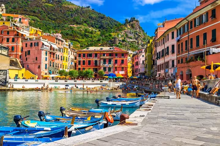 Vibrant Vernazza harbor in Cinque Terre with colorful boats and buildings, perfect for a small group tour from La Spezia.