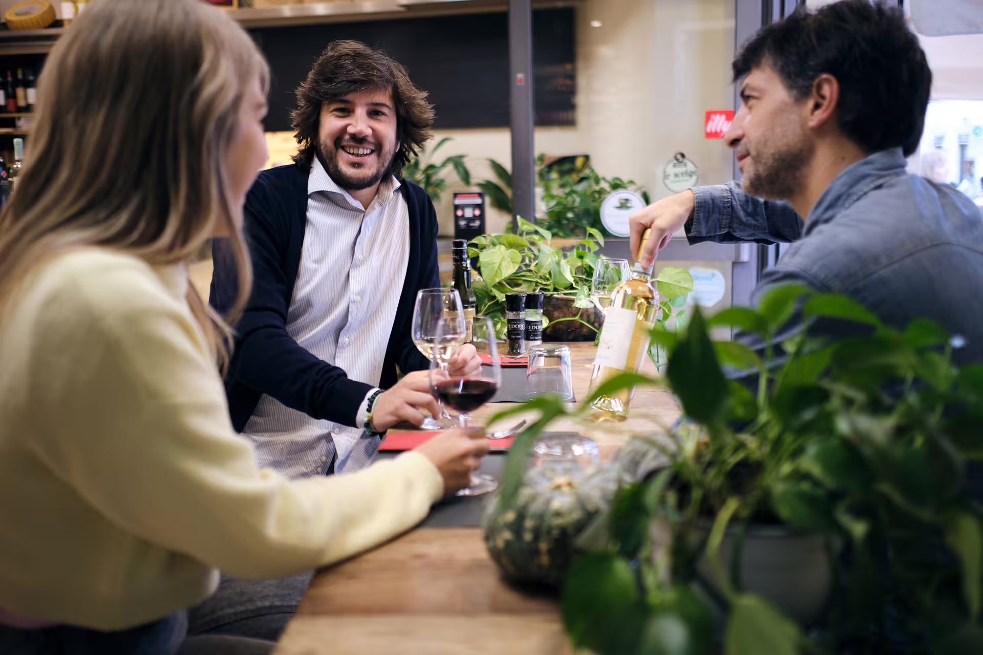 Guests enjoy wine tasting at a Verona food tour stop, sampling local reds at a cozy enoteca table