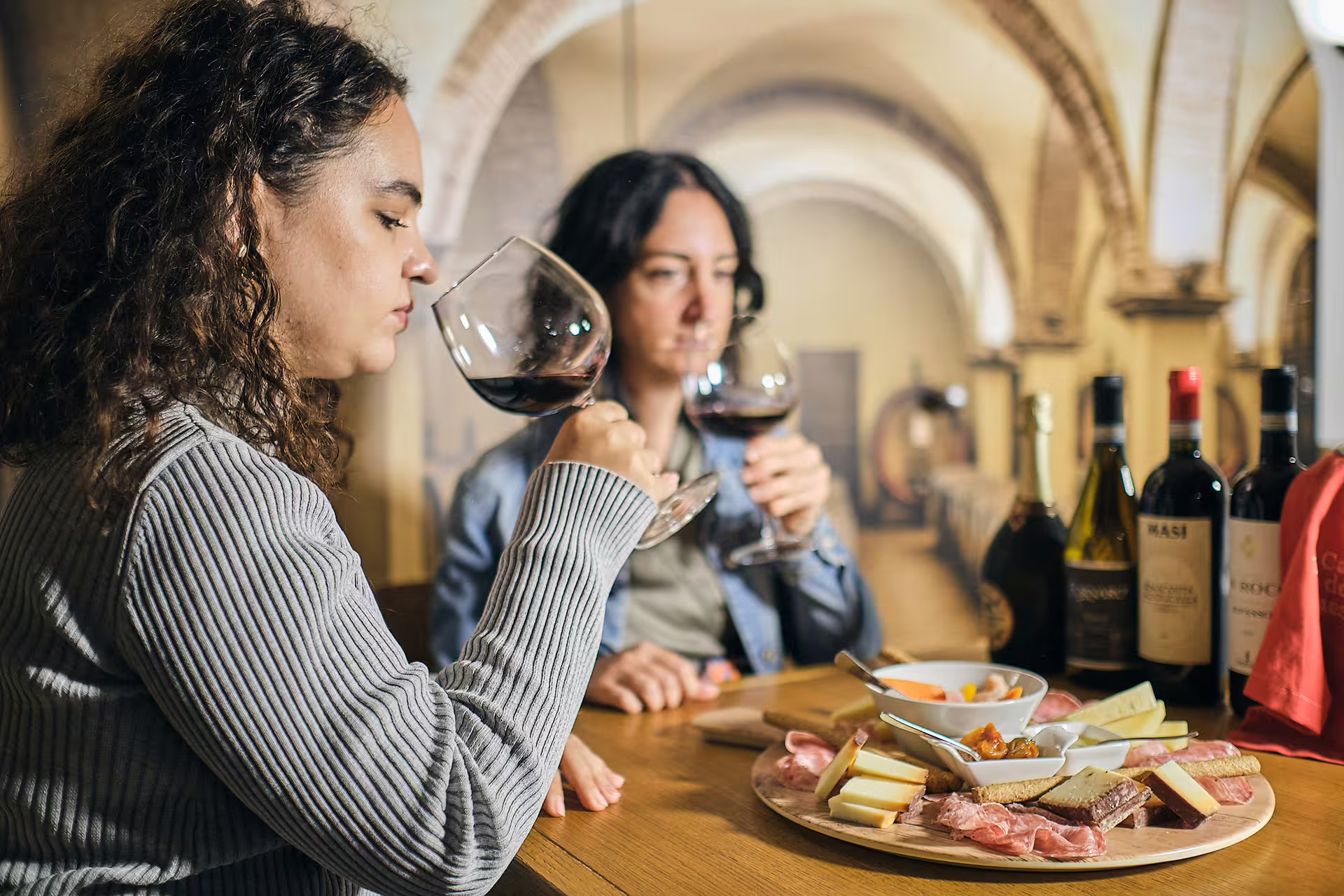 Guests swirl red wine with local cheese and salumi during Verona wine tasting near Juliet’s House cellar