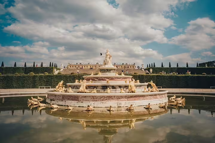 Admire the majestic Fountain of Versailles surrounded by lush gardens and historic architecture on our guided tour.