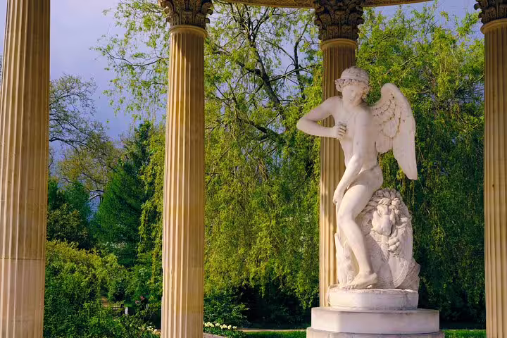 Classical marble statue in lush garden setting at Versailles, featured on Paris to Versailles guided tour in English.