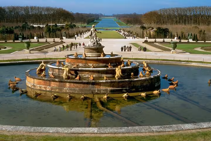 Latona Fountain with tiered basin and golden sculptures in the formal gardens of Palace of Versailles