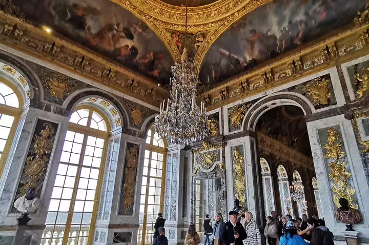 Hall of Mirrors at Versailles Palace with chandelier and gilded decor on skip-the-line guided tour